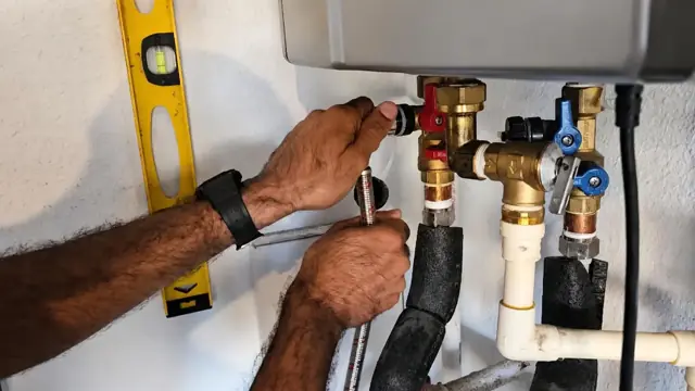 Hands fitting valves and a level on a tankless water heater